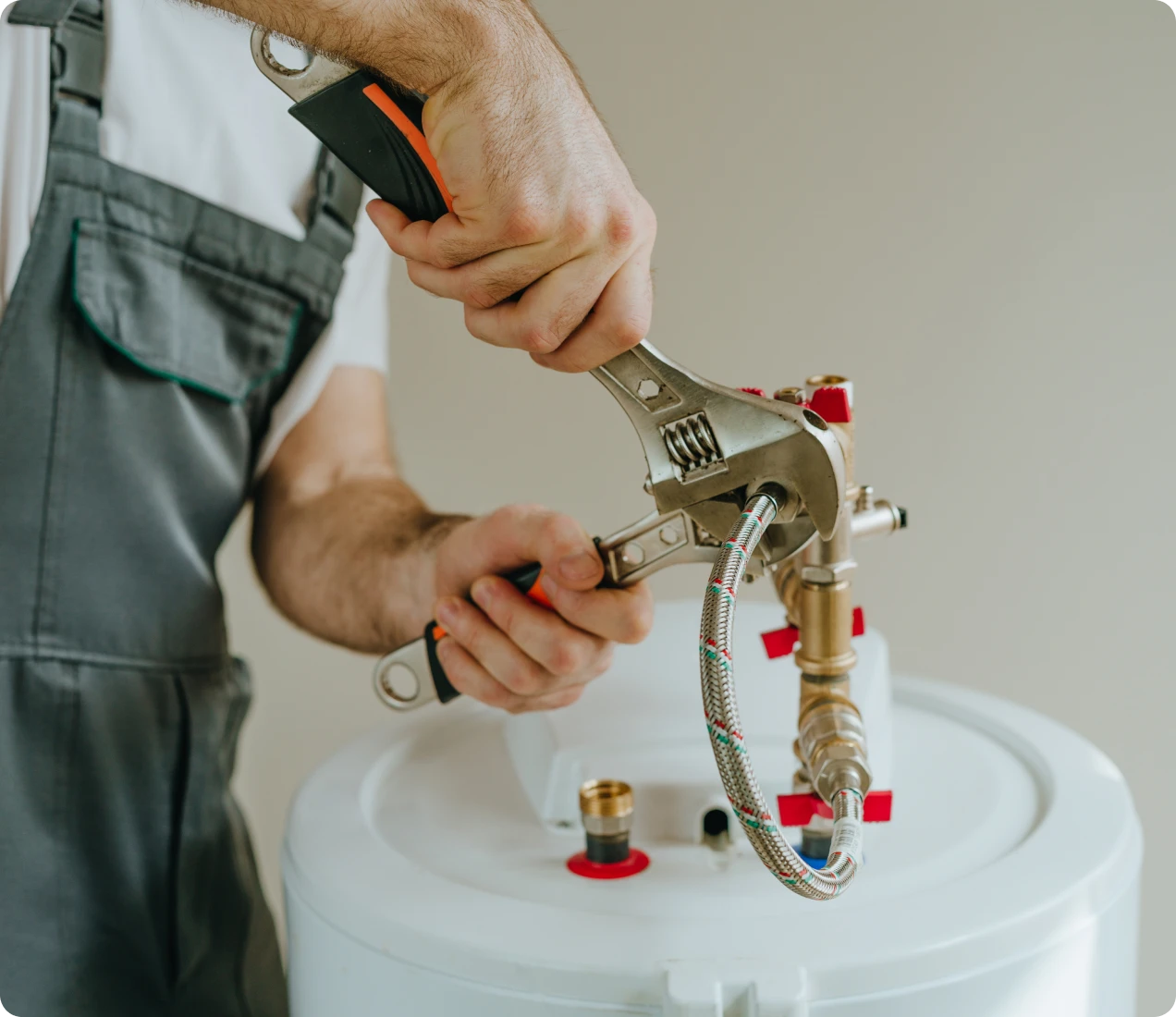 Plumber fixing water heater with wrench