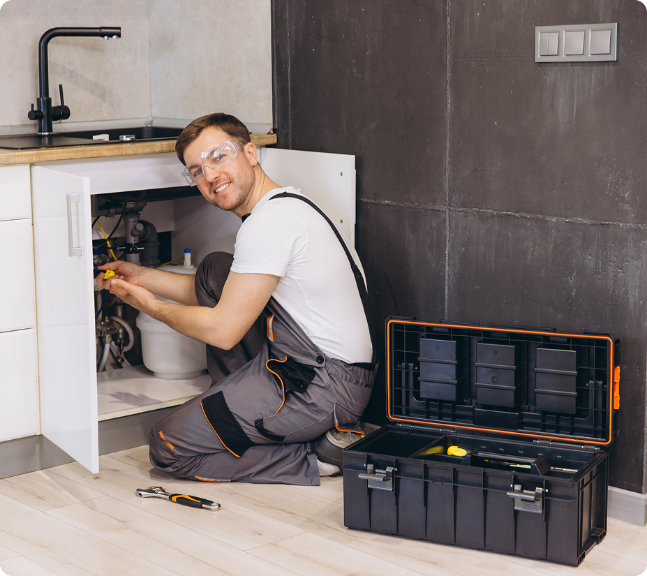 Plumber fixing kitchen sink pipes