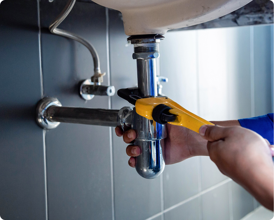 Plumber fixing sink pipe with wrench