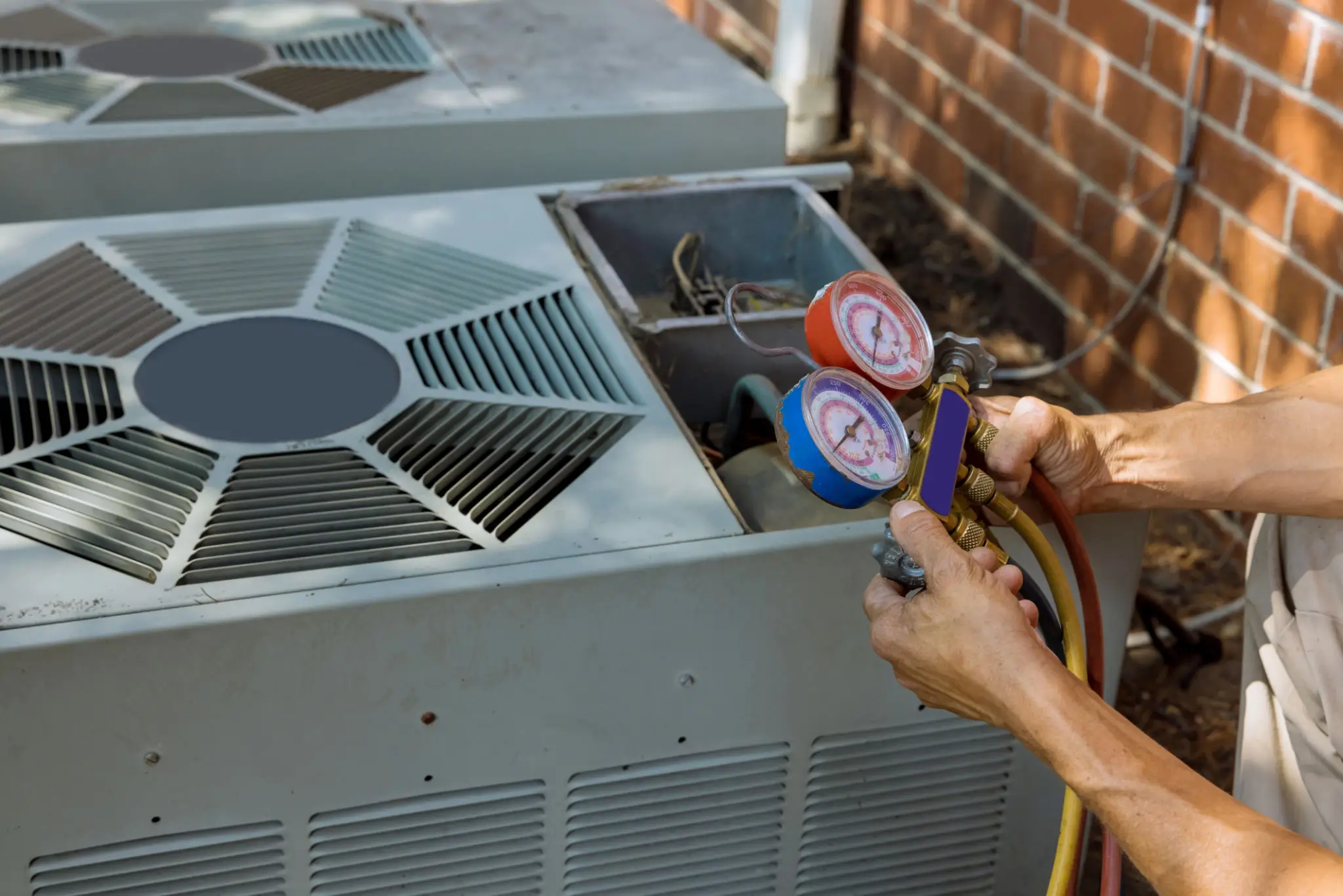 Technician checking HVAC system pressure with gauges.